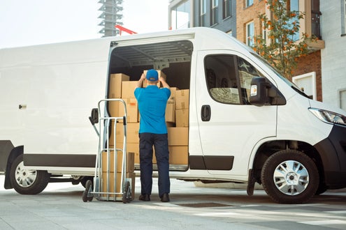 Worker unloading boxes from cargo van