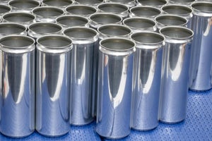 Tall metal cans with no lids on blue conveyor belt