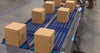 Boxes on blue roller conveyor | Activated Roller Belt