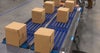 Cajas en un transportador de rodillos azul | Activated Roller Belt