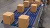 Boxes on blue roller conveyor | Activated Roller Belt
