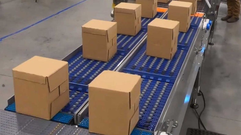 Boxes on blue roller conveyor | Activated Roller Belt