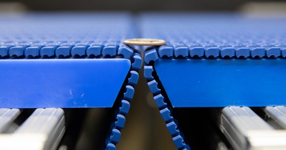 Coin straddling gap between Intralox Series 560 Tight Transfer belts