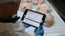 Mitarbeiter, der einen Tablet-Computer hält, um die Ergebnisse des FMC-Fördererprogramms von Intralox auf der Hähnchenlinie anzuzeigen