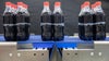 Pacote com seis refrigerantes de cola em garrafas PET na esteira de transferência de precisão Série 560