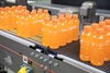 Lot de huit paquets de boissons pour sportifs orange en transfert sur des convoyeurs