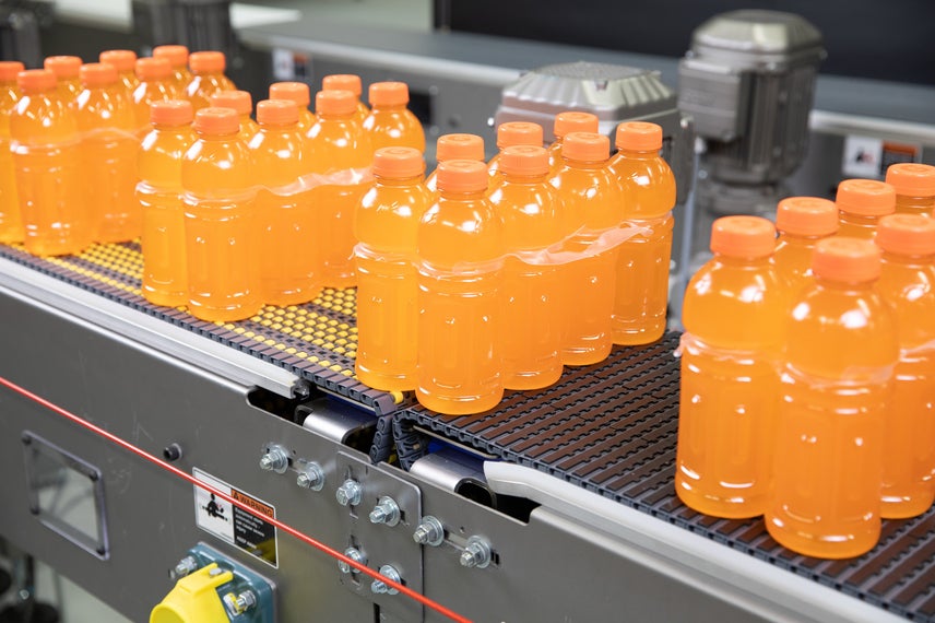 Transferencia de packs de ocho bebidas deportivas naranjas por los transportadores