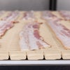 Uncooked bacon strips on Series 900 Raised Rib Heavy Duty Edge conveyor belt