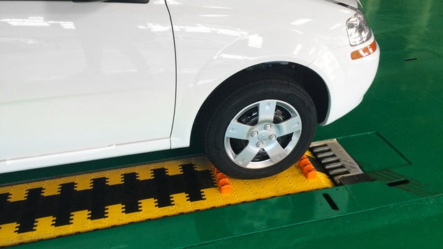 White car with front right tire on Series 10000 conveyor belt