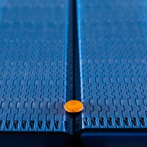 Penny-Münze auf Übergabespalt zwischen zwei Flat Top-Bändern der Serie 570
