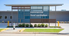 Exterior of building with sign that reads "Commerical Food Sanitation"