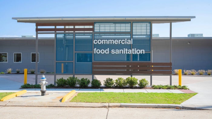 Exterior do prédio com uma placa que diz "Commerical Food Sanitation"