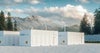 Große Lagercontainer für batteriebasierte Energiespeicherlösungen neben Solarmodulen und Windturbinen