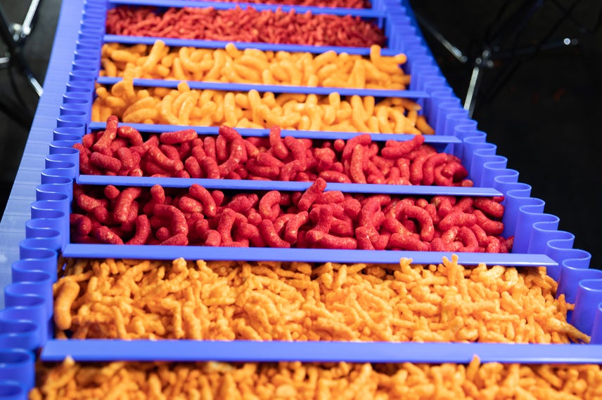Divers types de biscuits au fromage sur un tapis ThermoDrive A23 incliné avec taquets et flancs synchronisés
