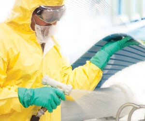 Worker lifting ThermoDrive belt to clean