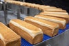 Miches de pain tournant sur un tapis transporteur à rayon de courbure Série 2400 HDE