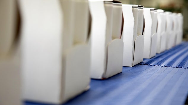 Row of white lightweight boxes on blue conveyors