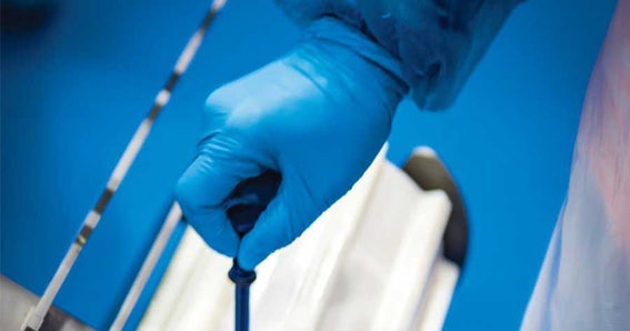 Mano con guanto sterile che regola la vite della ruota dentata