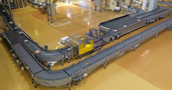 Overhead shot of M. Dias Branco installation with two equipment lines operating side by side around a curve