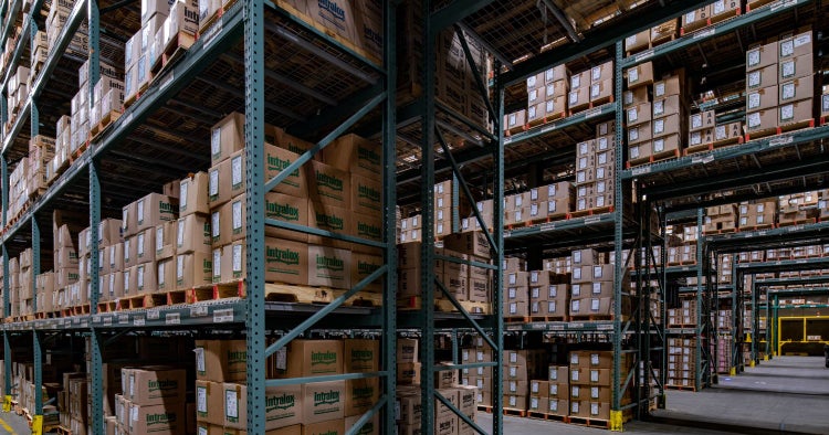 Intralox warehouse with stacked pallets of labeled boxes organized on high industrial shelving