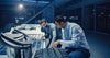 Two male office workers examining tires and automotive equipment