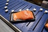 Paquete de bandejas con filete de salmón en porciones en el transportador AIM