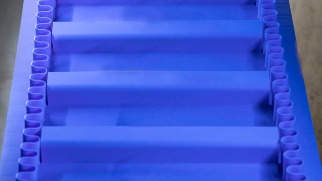 Intralox ThermoDrive-Aufwärtsförderband in A23-Material mit schaufelförmigen Mitnehmern und synchronisierten Seitenwänden