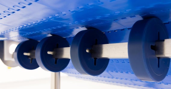 CleanLock rollers on conveyor shaft supporting blue conveyor belt