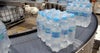 Shrink-wrapped bundles of bottled water rounding radius conveyor