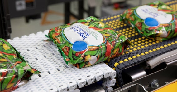 In Beutel verpacktes Gemüse auf Fördererübergabe