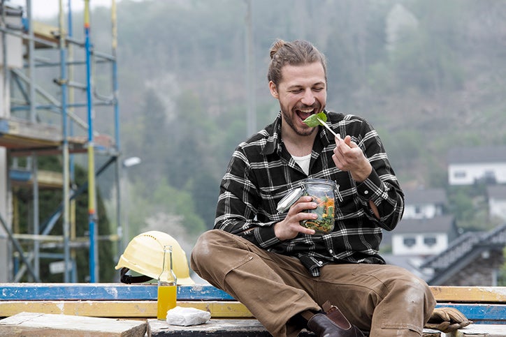 A man construction worker eats a high-fibre salad