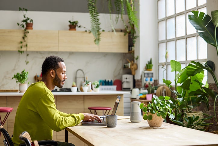 Man sitting at a workspace on a laptop