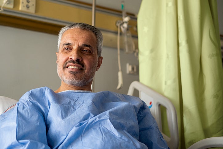 Middle aged male patient sitting up in a hospital bed
