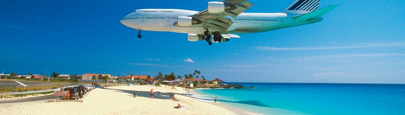 Airplane travelling over vacation beach