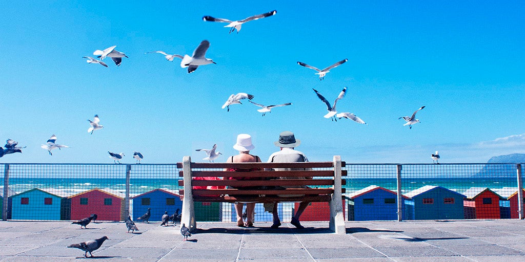 Senior Citizens with over 50s life insurance sitting along the beach