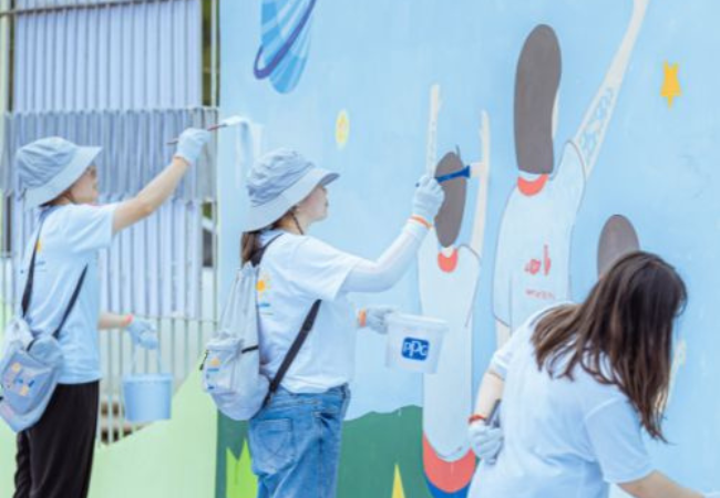 three women painting mural