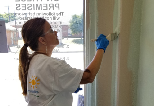 girl painting wall white