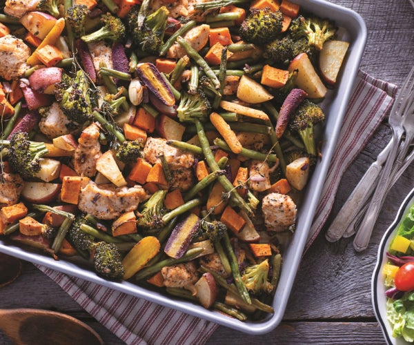 Roasted mixed vegetables in a silver tray on a kitchen side