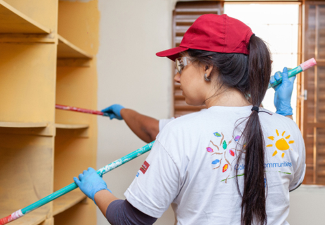 Volunteers painting a cabinet 