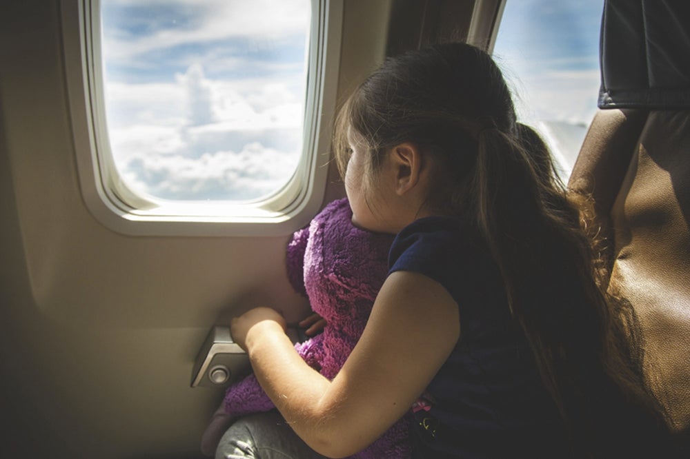 소녀가 비행기 창문을 보고 있다