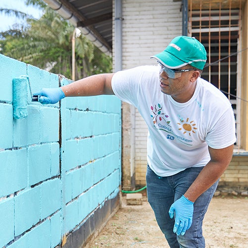 man painting wall blue in Prakiki School in Paramaribo, Suriname
