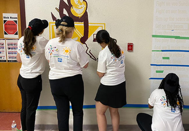 Girls painting devil mural on wall in Las Vegas, Nevada