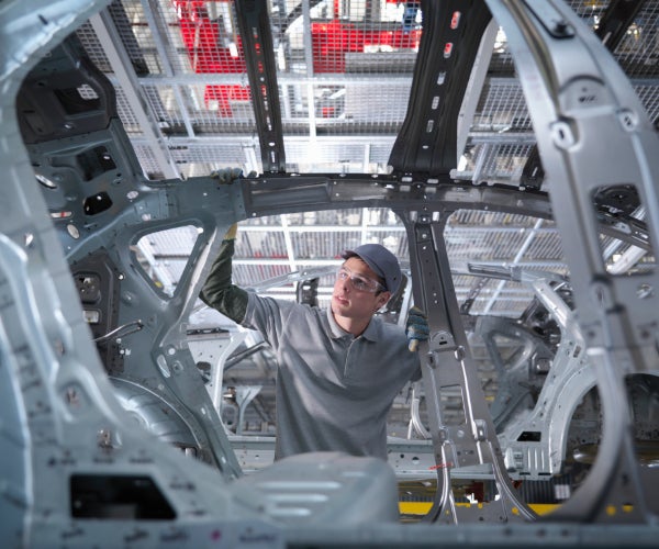 Man working on a car shell on a production line