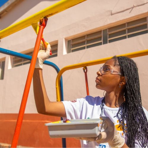 girl painting schoolground equipment 