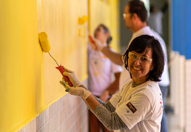 Woman painting wall yellow in Phinhais, Brazil 