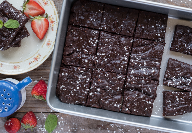 Bakeware with chocolate brownies and fruit