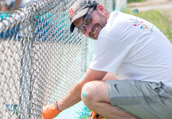 man painting fence blue