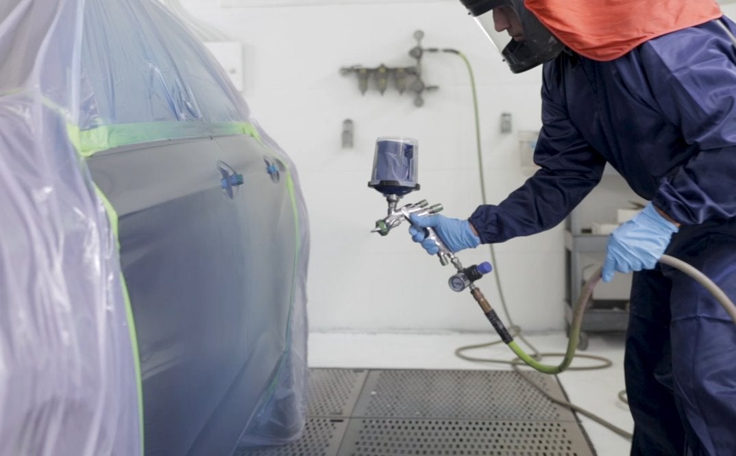 worker spraying car paint