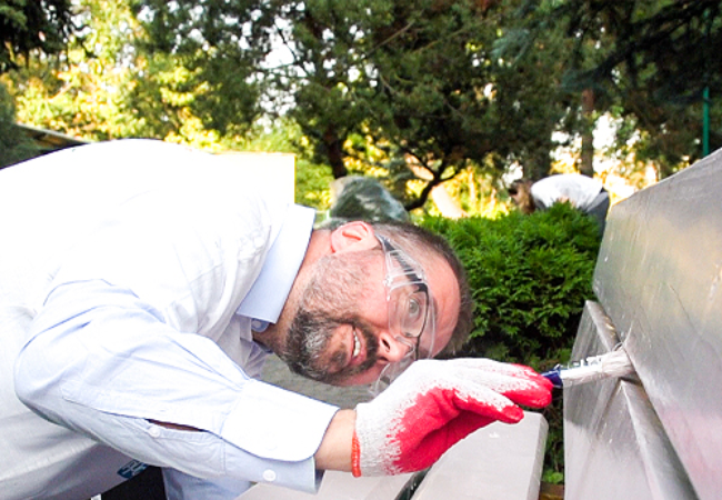 man painting bench in Worclaw, Poland 