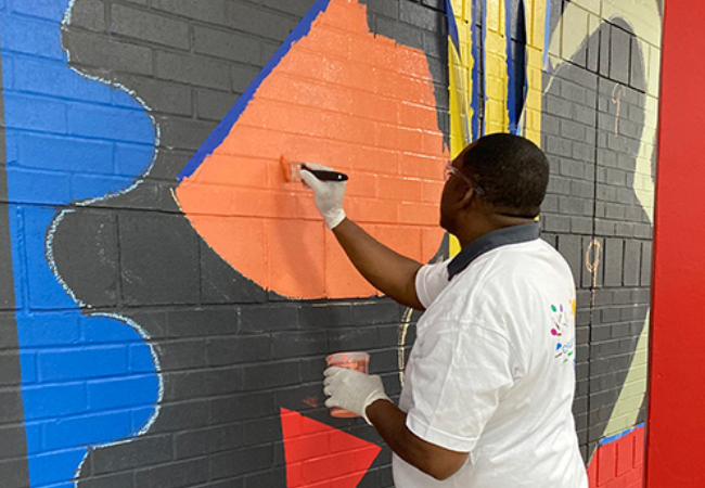 girl painting shapes murals in East Point, Georgia 